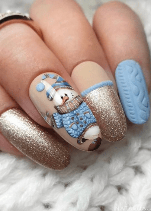 Light blue and gold winter nail design with a snowman dressed in winter clothes