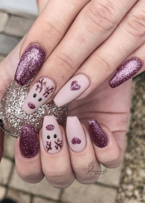 Pink and sparkly purple nail design with a reindeer