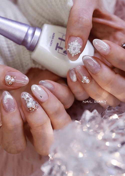 Light pink Christmas nail design with gems and rhinestones