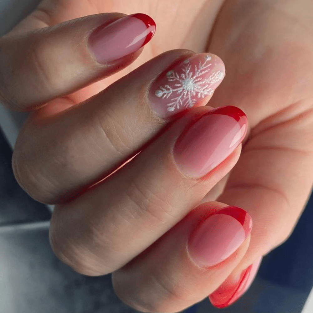 A nail design with red tips and a snowflake