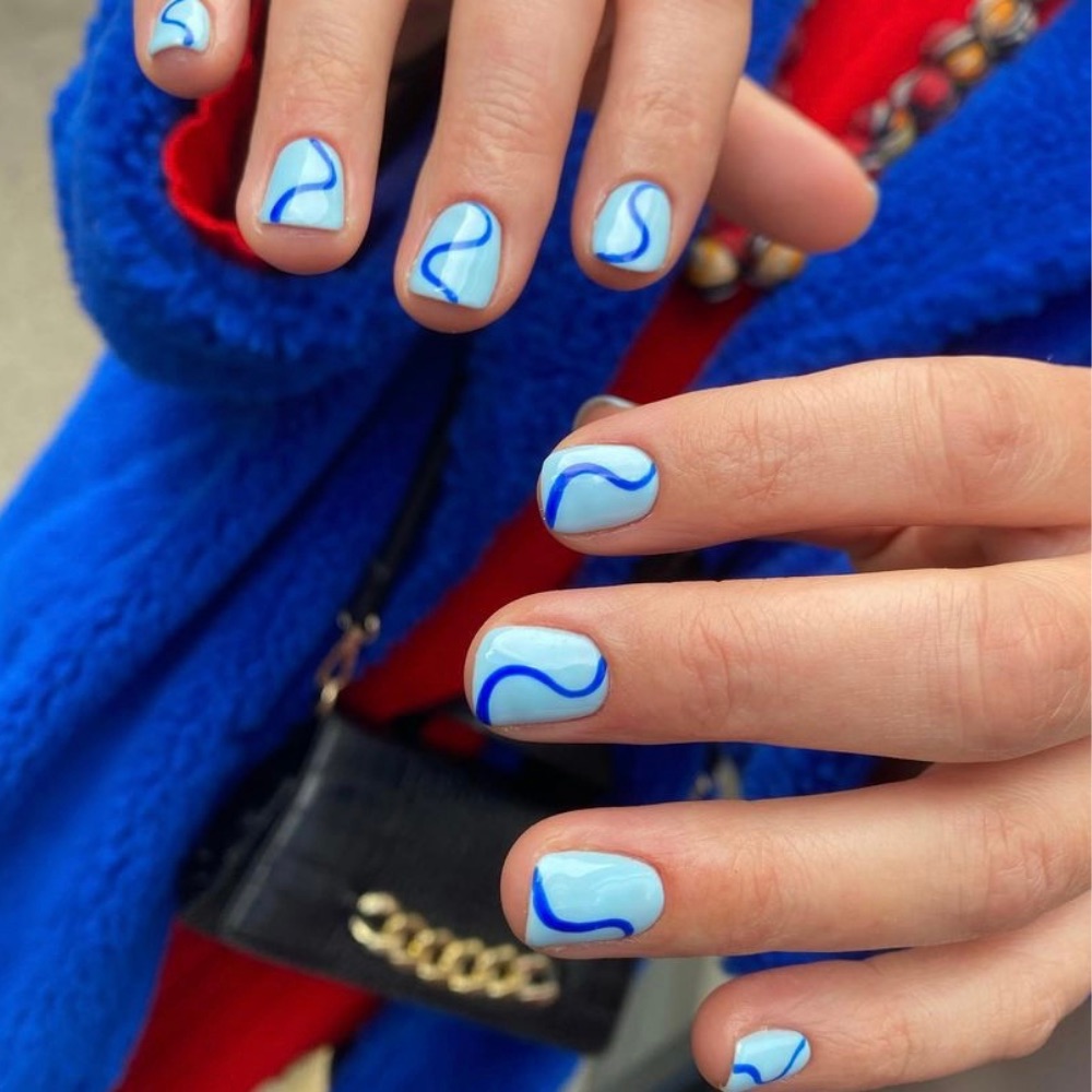 Simple short blue nails with a dark blue swirl in the middle