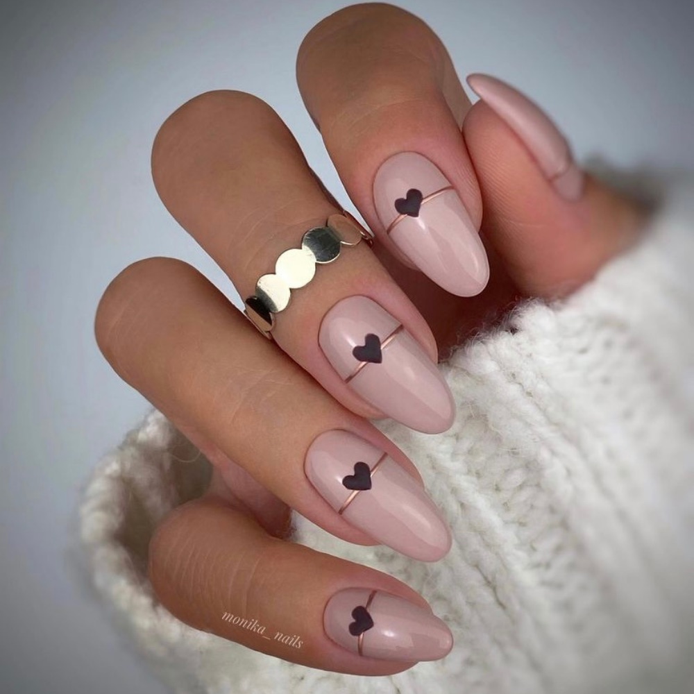 A simple nail design on oval shaped nails with a heart and line design